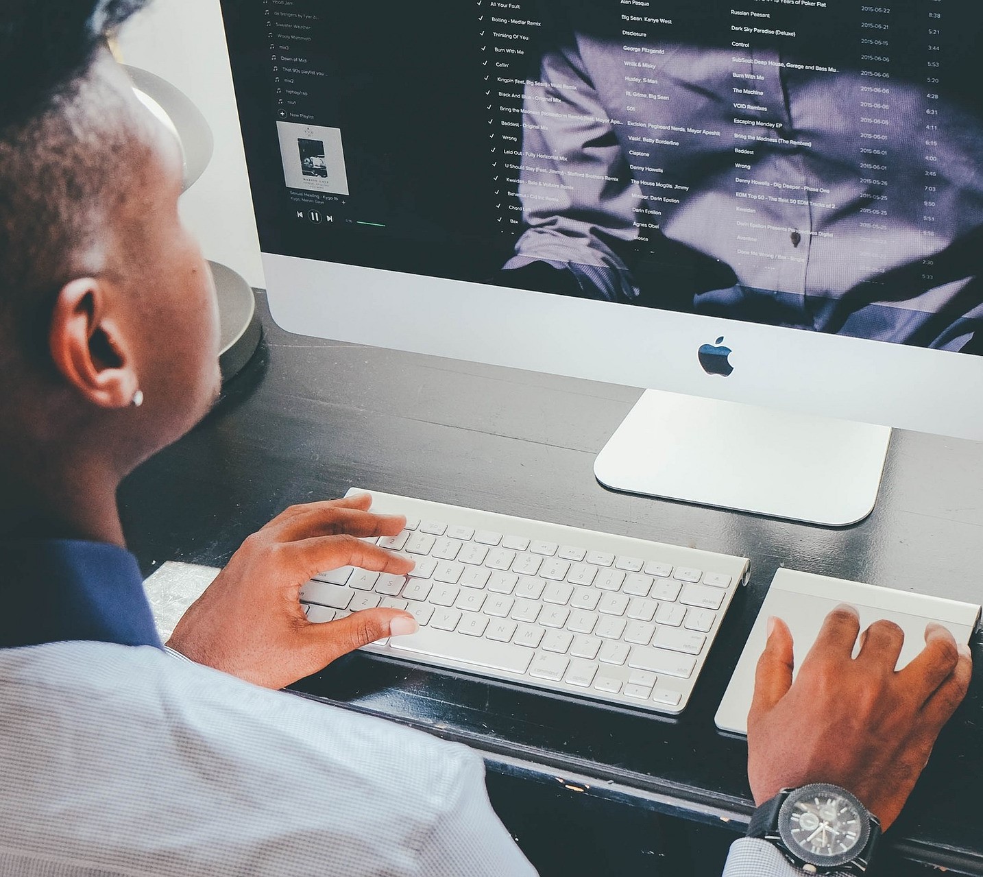 A person is working on an Apple desktop computer.